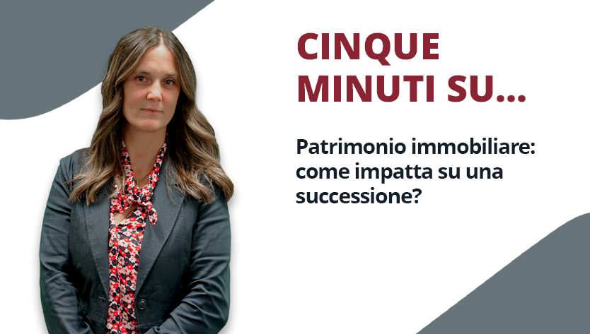 Una donna con un blazer nero e una camicetta a fiori posa con sicurezza su uno sfondo grigio e bianco. Il testo recita: “Cinque minuti su... Patrimonio immobiliare: come impatta su una successione?”