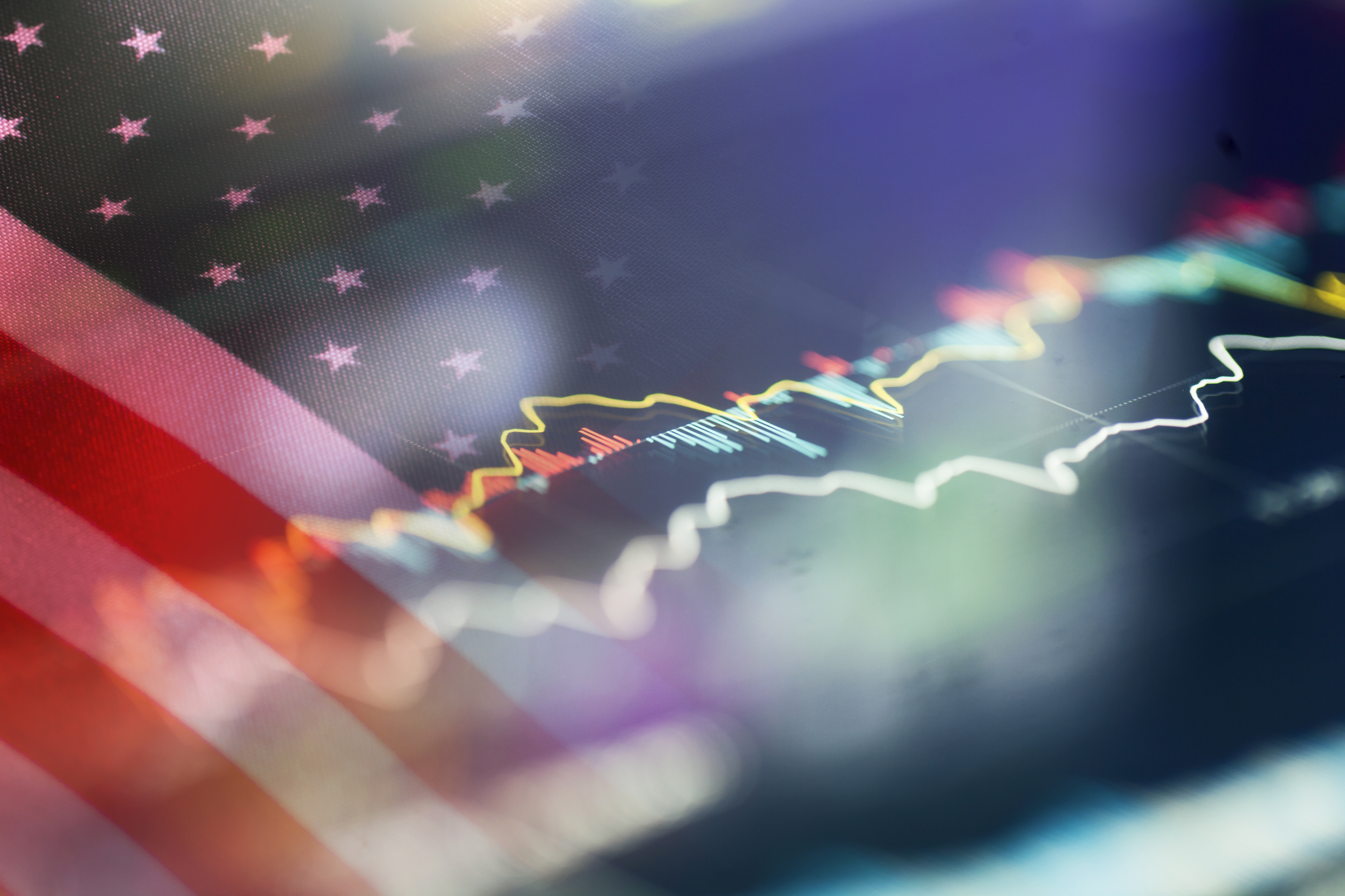 A blurred stock market graph overlays a faded American flag, symbolizing finance and patriotism.