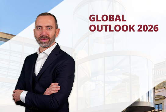 Un uomo in giacca e cravatta sta in piedi con sicurezza, a braccia conserte, sullo sfondo di un edificio moderno. Il testo recita: “Prospettive globali 2026, L'anno del Gattopardo”.