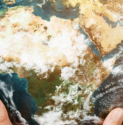 Mani che reggono un mappamondo incentrato sull'Africa, con continenti, nuvole e acqua in un'illustrazione colorata e dettagliata