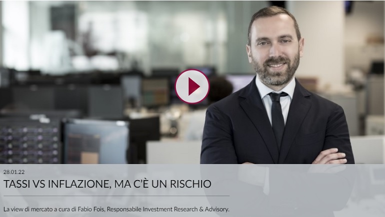 Un uomo in giacca e cravatta è in piedi davanti a un moderno ufficio dotato di schermi di computer